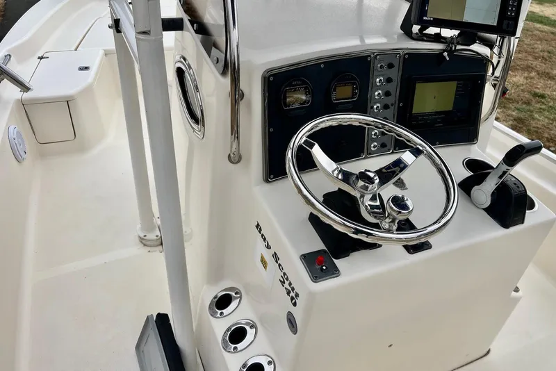 Slide: The Image of 2009 Scout 240 Bay Scout boat console with steering wheel and navigation equipment. - 12