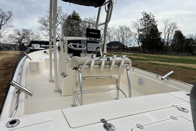 Slide: The Image of 2009 Scout 240 Bay Scout boat with steering console and rod holders, parked outdoors. - 14