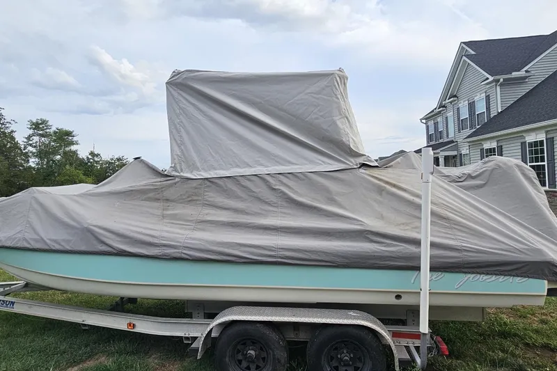 Slide: The Image of Covered 2009 Scout 240 Bay Scout boat on trailer near house. - 26