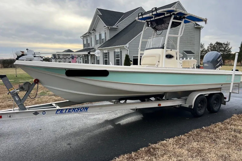Slide: The Image of 2009 Scout 240 Bay Scout boat on trailer, parked in front of a house. - 3