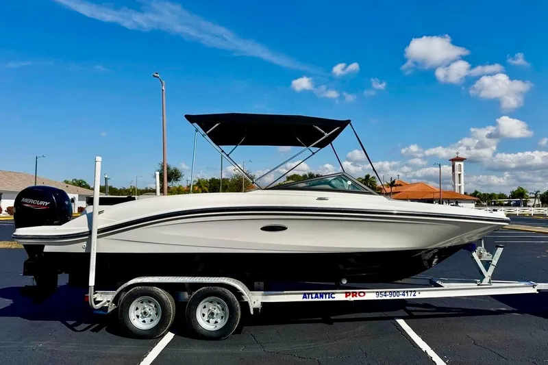 Slide: The Image of 2023 Sea Ray SPX 210 Outboard boat on trailer under clear blue sky. - 1