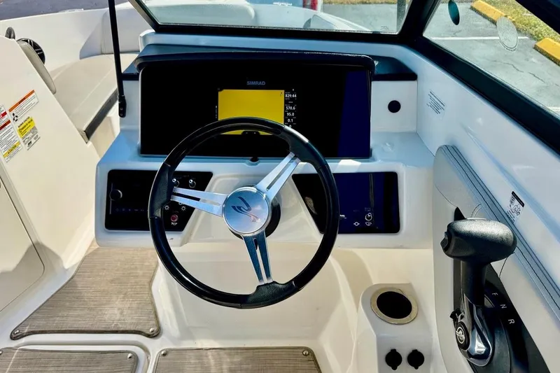 Slide: The Image of 2023 Sea Ray SPX 210 Outboard dashboard with steering wheel and control panel. - 15