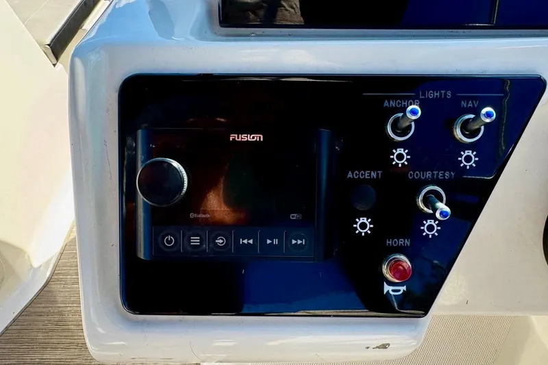 Slide: The Image of Control panel of 2023 Sea Ray SPX 210 Outboard with Fusion audio system and switches. - 17