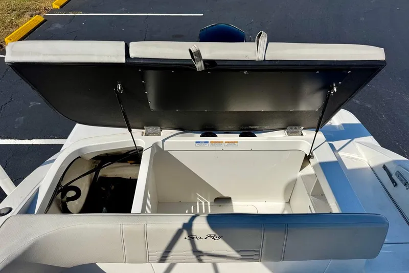 Slide: The Image of 2023 Sea Ray SPX 210 Outboard boat storage compartment open, showcasing interior space. - 24