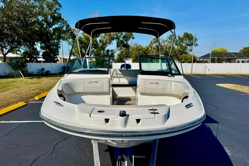Slide: The Image of 2023 Sea Ray SPX 210 Outboard boat with canopy, parked on asphalt. - 3