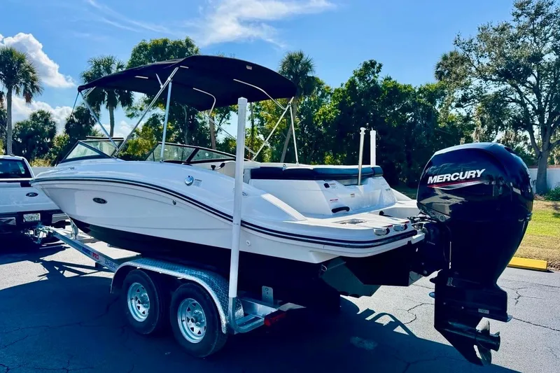 Slide: The Image of 2023 Sea Ray SPX 210 Outboard boat on trailer, featuring Mercury engine, parked outdoors. - 7