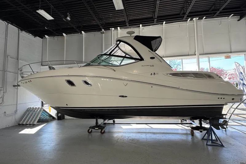 Slide: The Image of 2014 Searay 330 Sundancer boat displayed indoors on stands. - 1