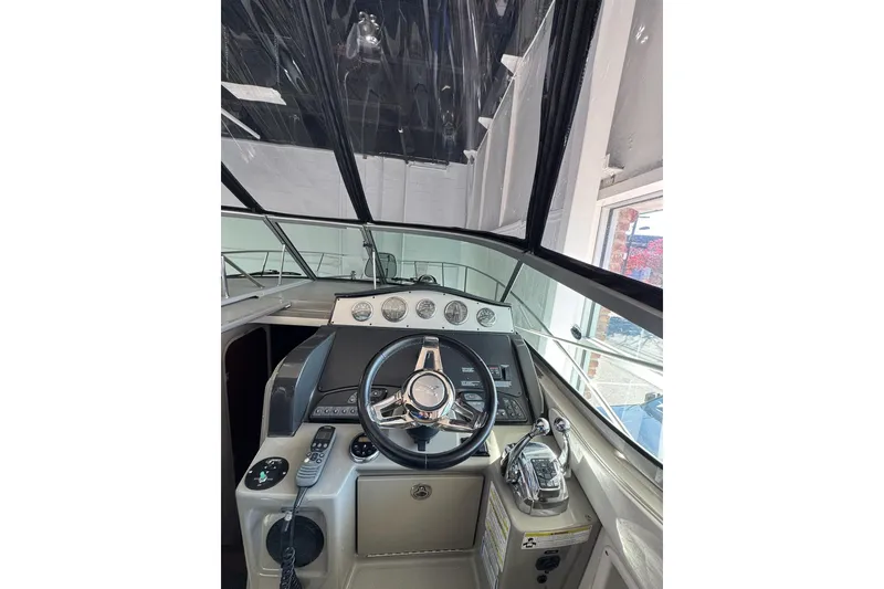 Slide: The Image of 2014 Searay 330 Sundancer boat interior with helm and seating area. - 10