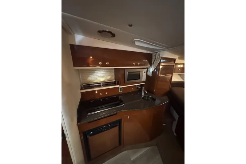 Slide: The Image of 2014 Searay 330 Sundancer cabin interior with cozy bed and ambient lighting. - 19