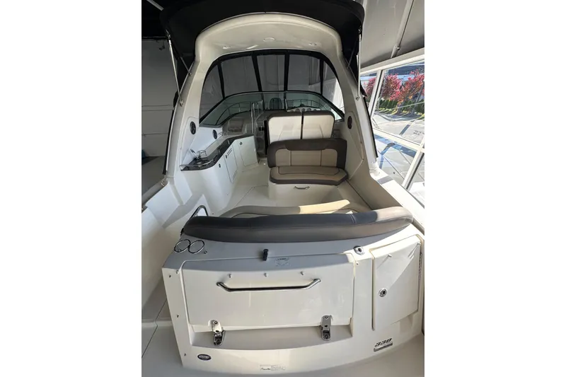 Slide: The Image of 2014 Searay 330 Sundancer boat interior with seating and helm, in a showroom setting. - 5