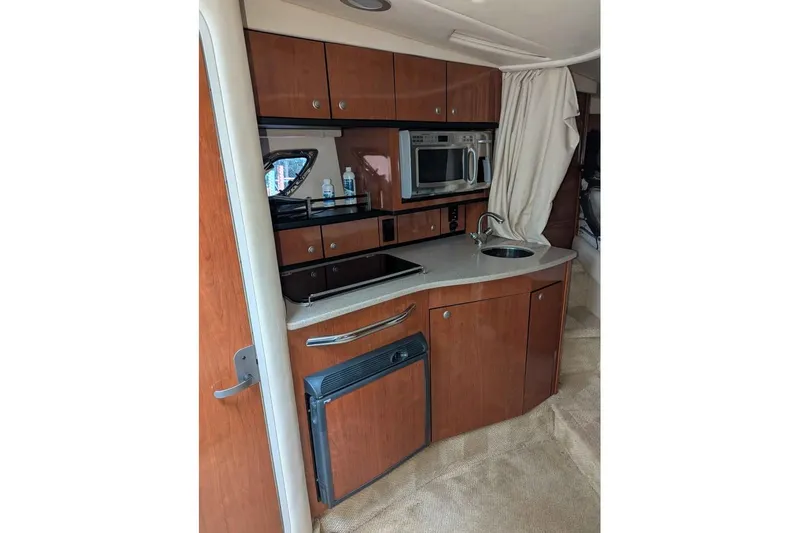 Slide: The Image of 2007 Sea Ray 310 Sundancer interior kitchen with wood cabinets and modern appliances. - 11