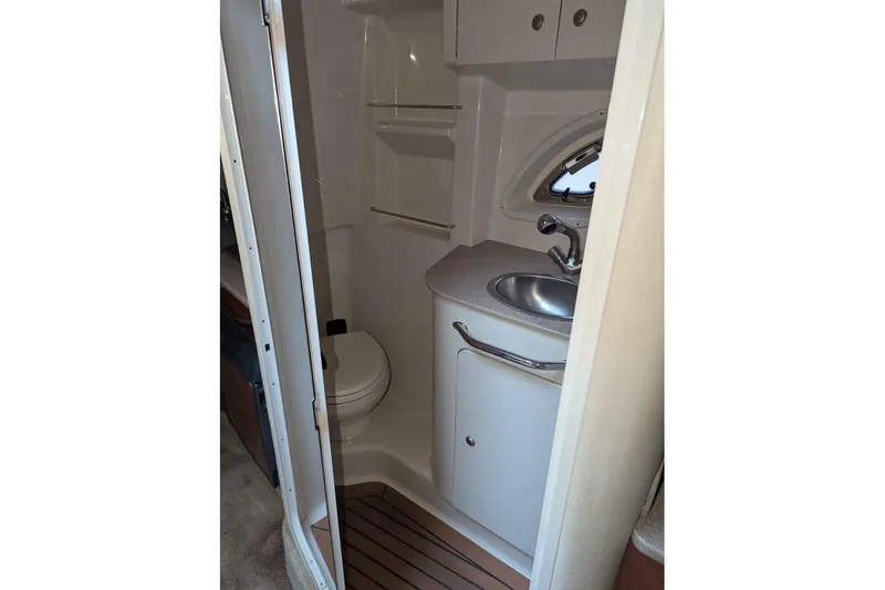 Slide: The Image of 2007 Sea Ray 310 Sundancer bathroom with sink, toilet, and storage cabinets. - 16