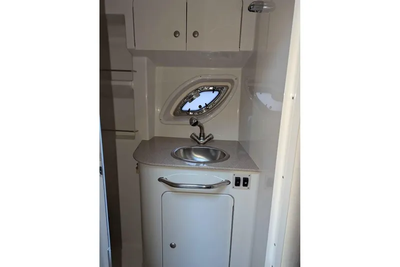 Slide: The Image of 2007 Sea Ray 310 Sundancer bathroom with sink and porthole window. - 18