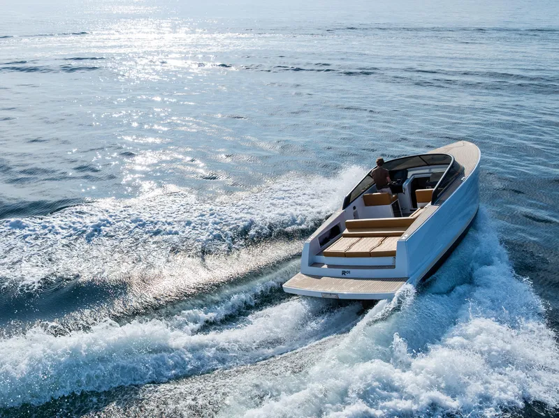 Slide: The Image of 2023 VanDutch 32 yacht cruising on open water, creating waves under a clear sky. - 10