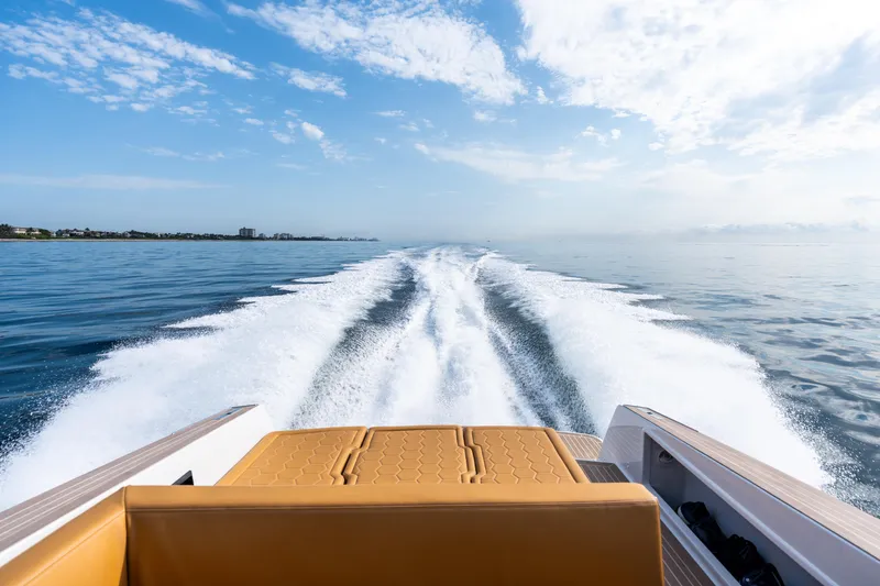 Slide: The Image of 2023 VanDutch 32 yacht cruising on open water, leaving a wake under a clear blue sky. - 12