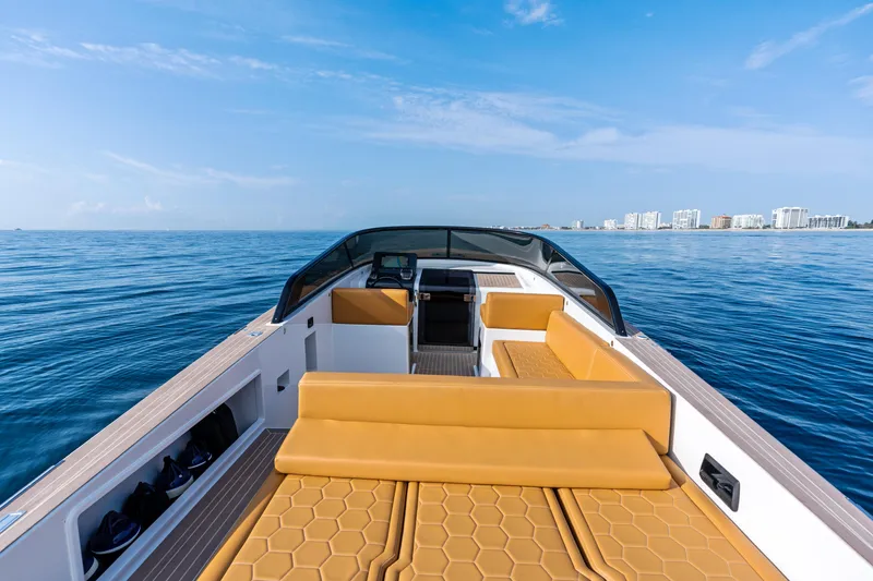 Slide: The Image of 2023 VanDutch 32 yacht with tan seating, cruising on a calm ocean under a clear blue sky. - 13