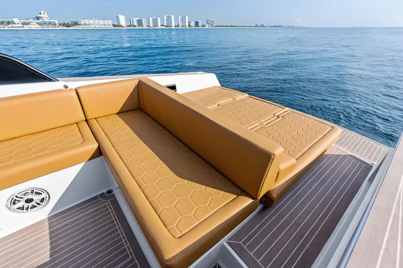 Slide: The Image of Luxurious 2023 VanDutch 32 yacht with tan seating, ocean view, and city skyline in the background. - 19