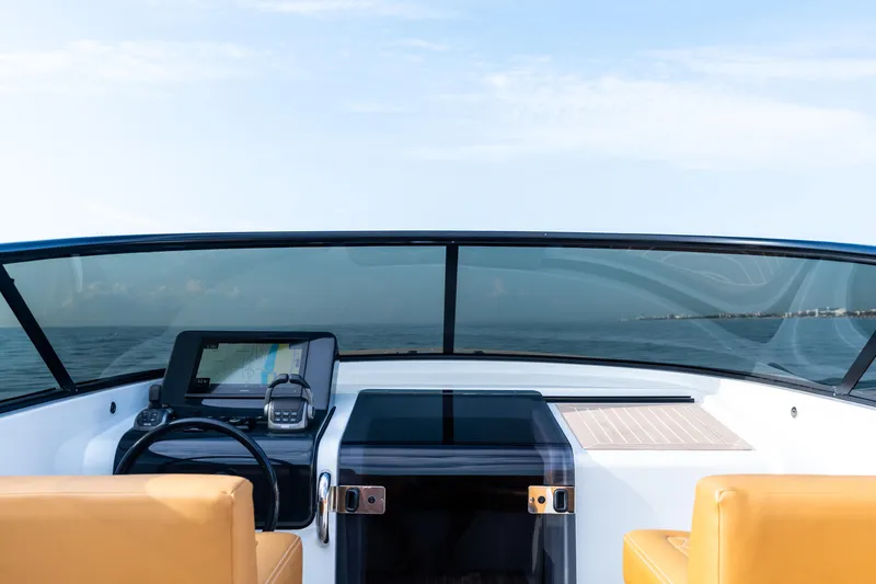 Slide: The Image of 2023 VanDutch 32 yacht cockpit with ocean view, featuring modern navigation equipment and tan seating. - 32