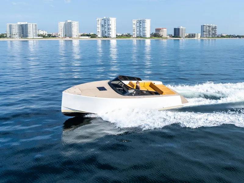 Slide: The Image of 2023 VanDutch 32 yacht cruising on calm waters with city skyline in background. - 5