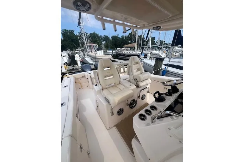 Slide: The Image of 2023 Grady-White Canyon 306 boat interior with dual white captain seats at marina. - 10