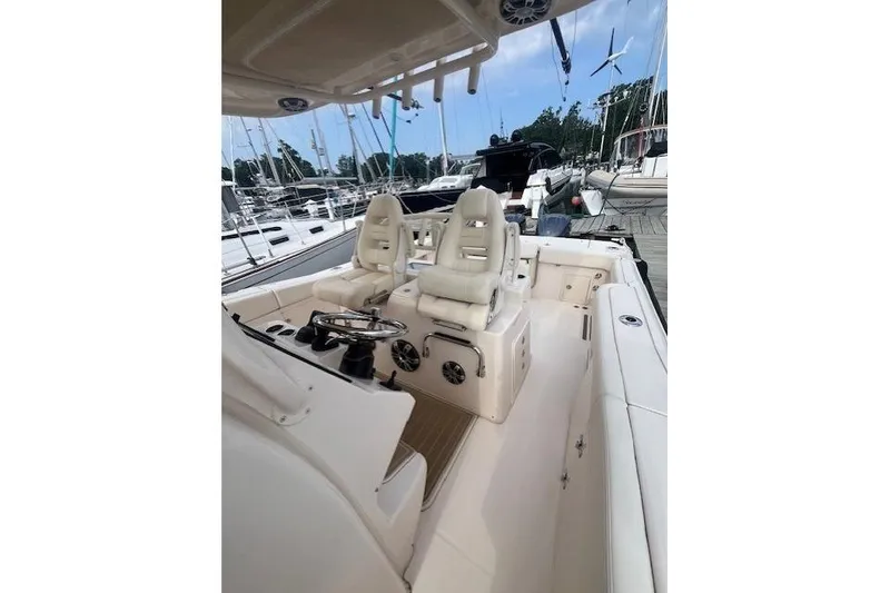 Slide: The Image of 2023 Grady-White Canyon 306 boat interior with helm and seating at marina. - 11