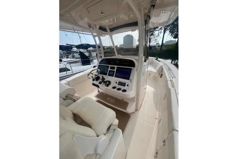 Slide: The Image of 2023 Grady-White Canyon 306 boat interior with helm, steering wheel, and navigation controls. - 12