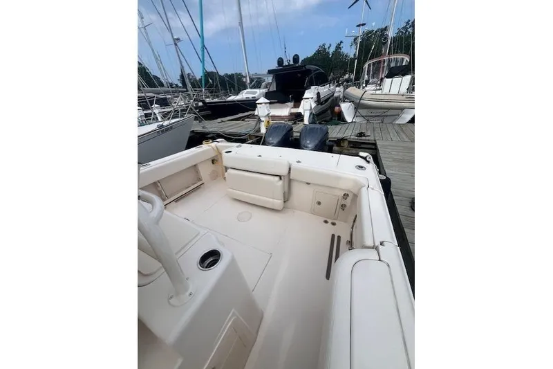 Slide: The Image of 2023 Grady-White Canyon 306 boat docked, showcasing spacious deck and seating area. - 15