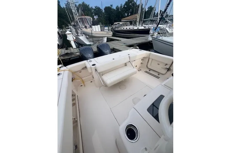 Slide: The Image of 2023 Grady-White Canyon 306 boat docked, featuring spacious deck and dual engines. - 16