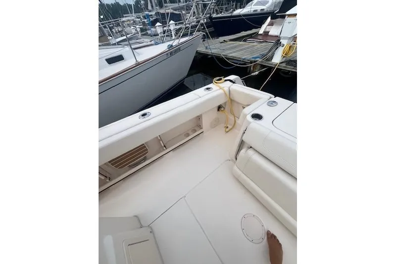 Slide: The Image of 2023 Grady-White Canyon 306 boat interior at marina, featuring seating and docked vessels. - 17