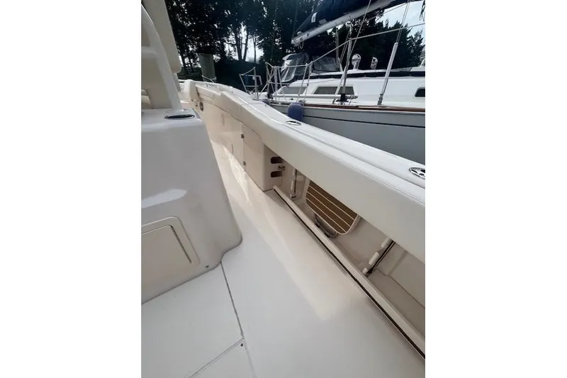 Slide: The Image of 2023 Grady-White Canyon 306 boat deck, sleek design, spacious layout, docked beside another vessel. - 19