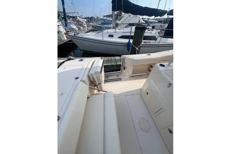 Slide: The Image of 2023 Grady-White Canyon 306 boat interior at marina, showcasing seating and deck layout. - 23