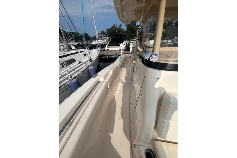 Slide: The Image of 2023 Grady-White Canyon 306 boat docked, showcasing sleek design and spacious deck. - 6