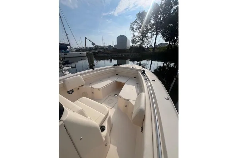 Slide: The Image of 2023 Grady-White Canyon 306 boat interior at a marina, under a clear sky. - 7