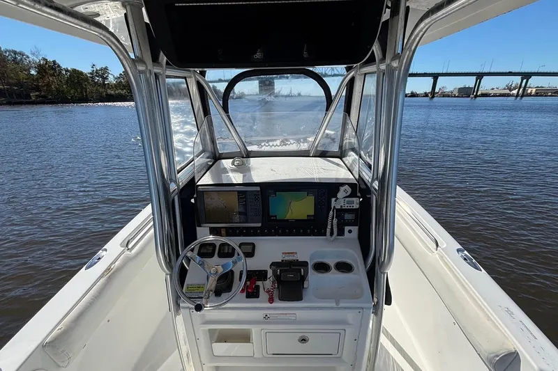 Slide: The Image of 2011 Sea Hunt Gamefish 25 boat console with navigation equipment on calm water. - 10