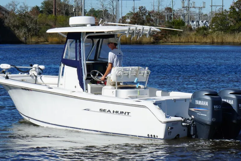 Slide: The Image of 2011 Sea Hunt Gamefish 25 boat with dual Yamaha engines on a calm river. - 8
