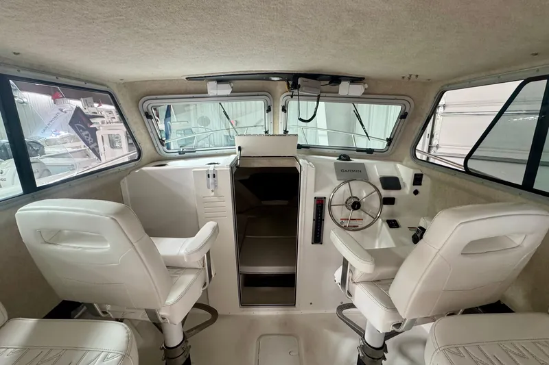 Slide: The Image of Interior of 2026 Parker 2520 XLD Sport Cabin with white seating and navigation equipment. - 11