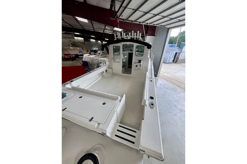 Slide: The Image of 2026 Parker 2520 XLD Sport Cabin boat in a showroom, showcasing spacious deck and cabin. - 4