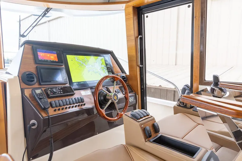 Slide: The Image of Manufacturer Provided Image: Interior helm of 2025 Ranger Tugs R-43 CB with navigation screens and controls. - 5