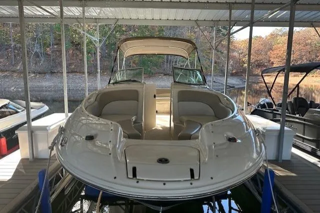 Slide: The Image of 2002 Sea Ray 240 Sundeck boat docked under a covered marina. - 11