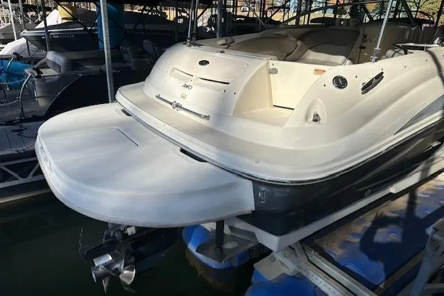Slide: The Image of 2002 Sea Ray 240 Sundeck boat docked, rear view showing swim platform and seating area. - 12