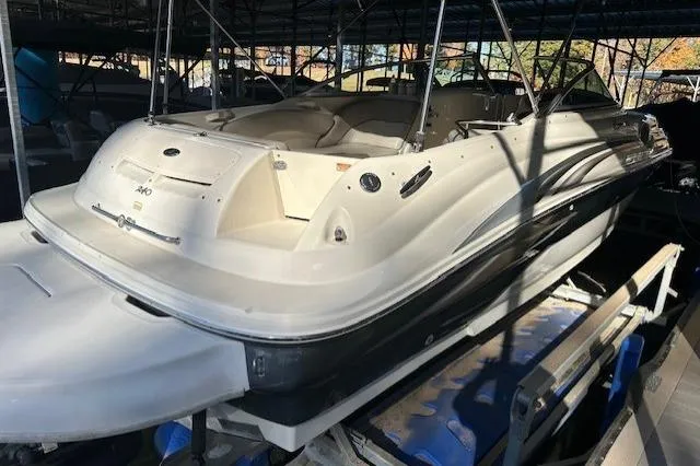 Slide: The Image of 2002 Sea Ray 240 Sundeck boat in a covered marina, showcasing sleek design and spacious seating. - 13