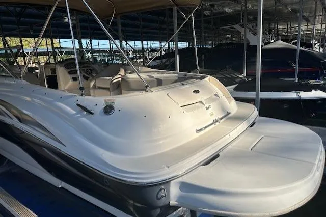 Slide: The Image of 2002 Sea Ray 240 Sundeck boat docked in a marina, showcasing spacious deck design. - 14