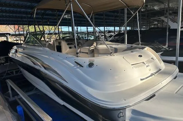 Slide: The Image of 2002 Sea Ray 240 Sundeck boat docked under a covered marina. - 15