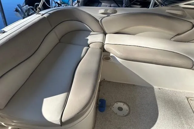 Slide: The Image of 2002 Sea Ray 240 Sundeck interior seating with beige upholstery and cup holders. - 20