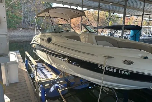 Slide: The Image of 2002 Sea Ray 240 Sundeck boat docked under a covered marina. - 7
