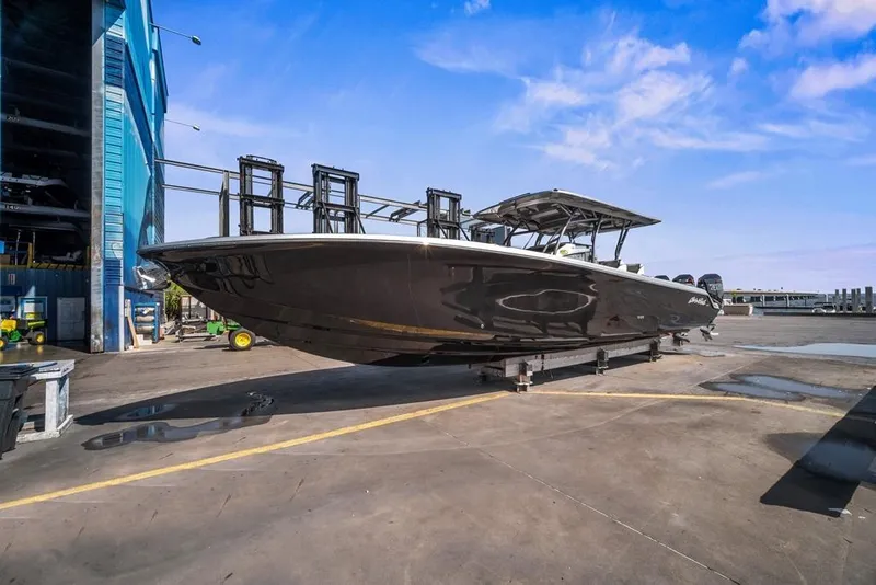 Slide: The Image of 2021 Nor-Tech 390 Sport Center Console boat on dry dock under blue sky. - 12
