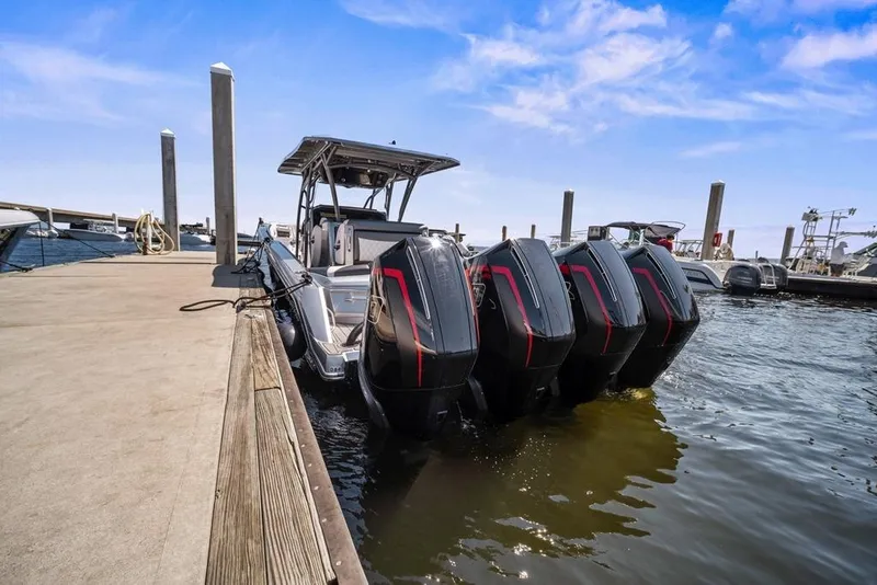 Slide: The Image of 2021 Nor-Tech 390 Sport Center Console docked with four powerful outboard engines. - 13
