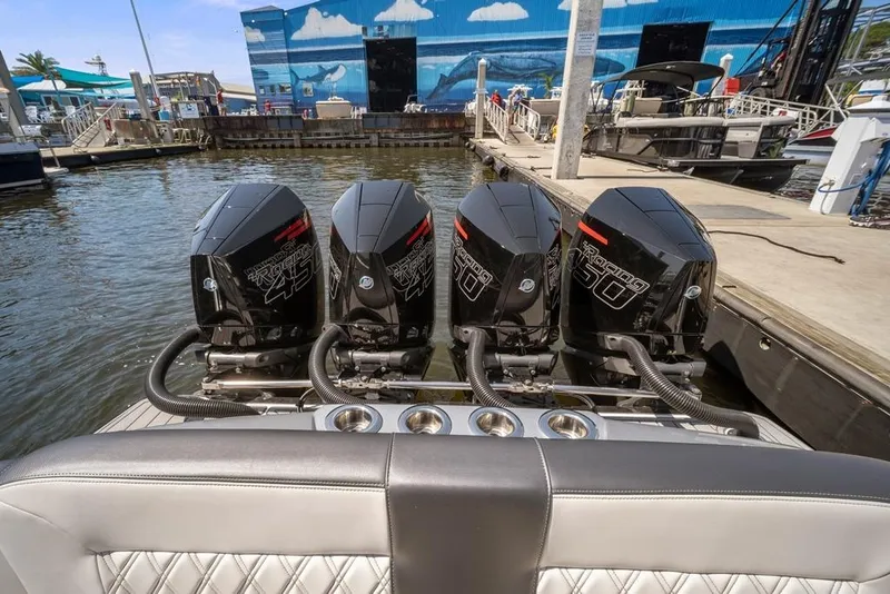 Slide: The Image of 2021 Nor-Tech 390 Sport Center Console with four powerful outboard engines at a marina. - 14