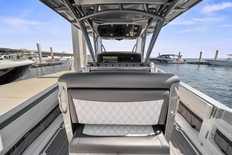 Slide: The Image of 2021 Nor-Tech 390 Sport Center Console at marina, showcasing helm and seating. - 21
