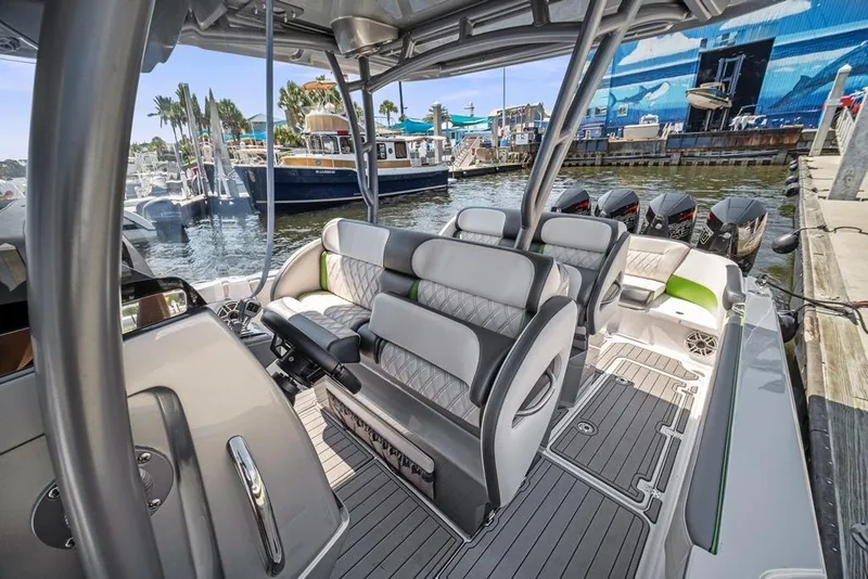 Slide: The Image of 2021 Nor-Tech 390 Sport Center Console boat interior with luxurious seating and multiple outboard engines. - 22